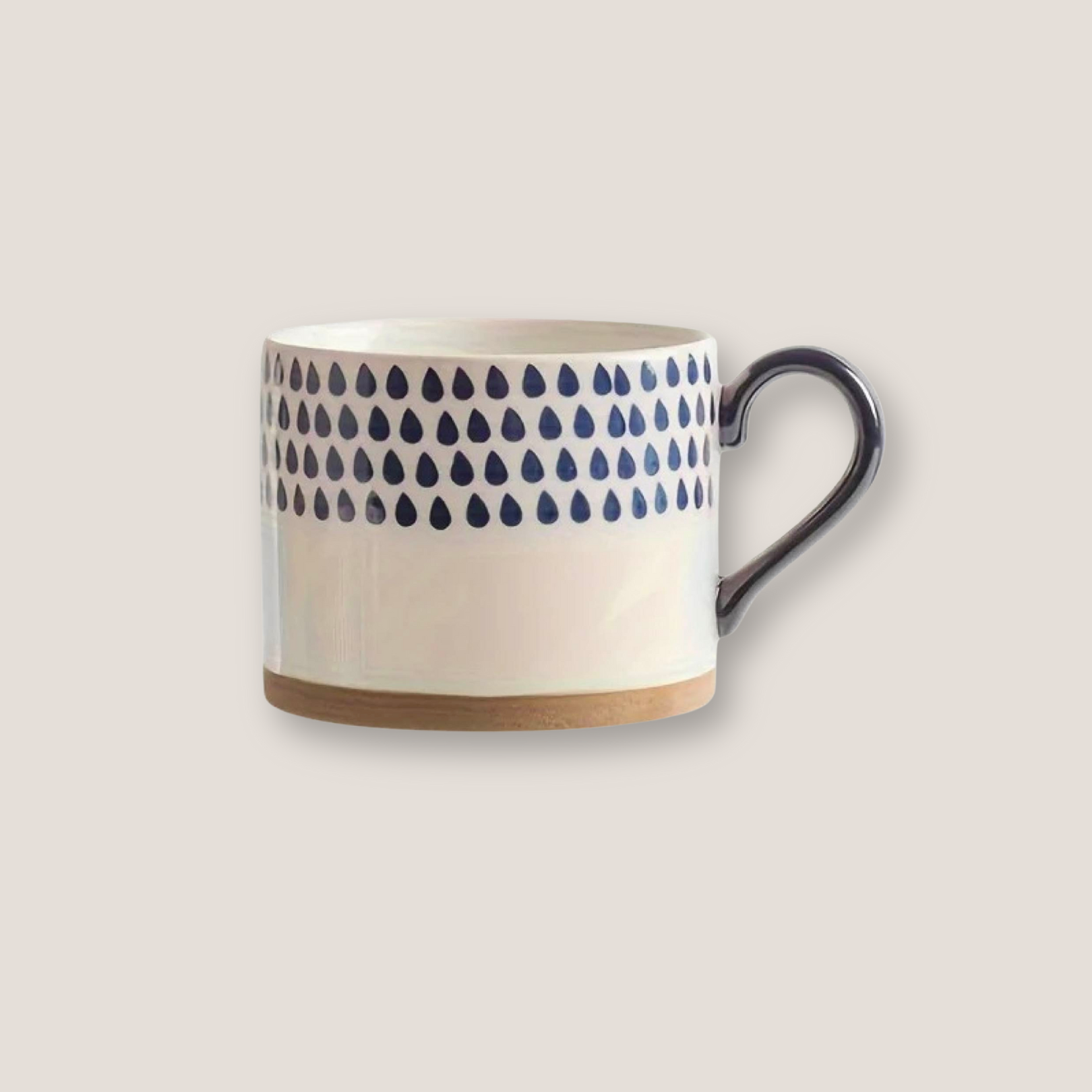 White ceramic artisan mug with hand-painted blue ink pattern and black handle shown from side view