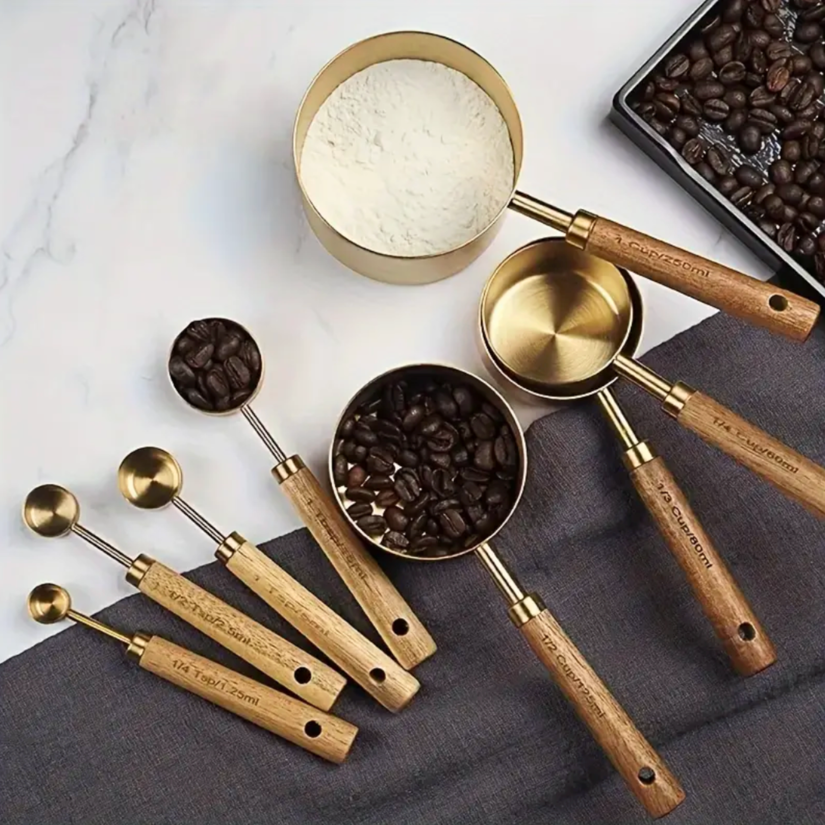 Gold measuring cups and spoons arranged together as a styled kitchen accessory set