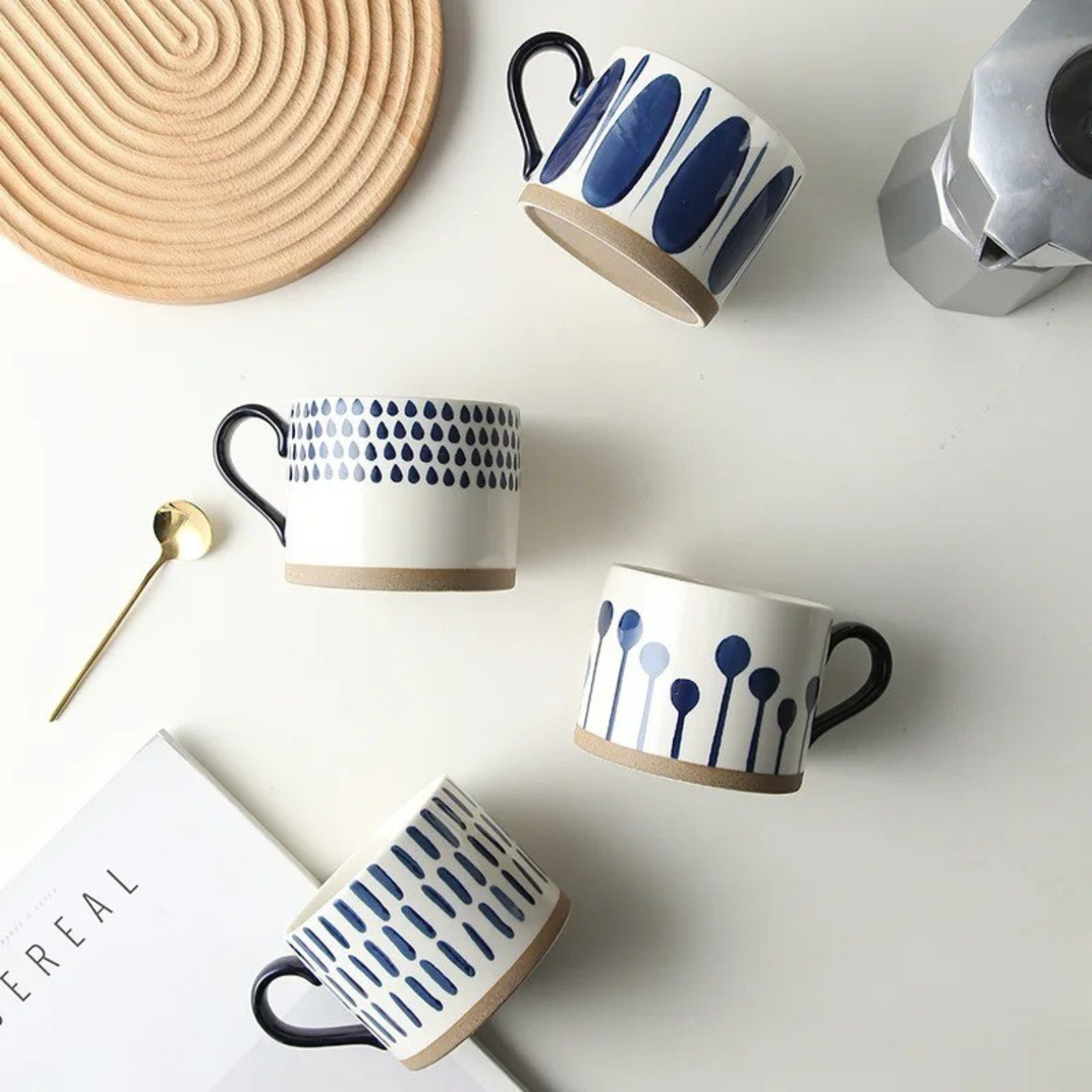 Ceramic artisan mug laid flat in a cozy lifestyle setting, showcasing its handcrafted shape and speckled finish