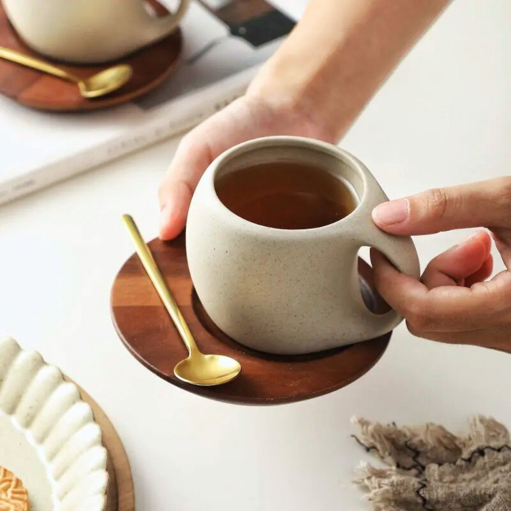 Ceramic cups on wooden bases with spoons styled in a lifestyle setup