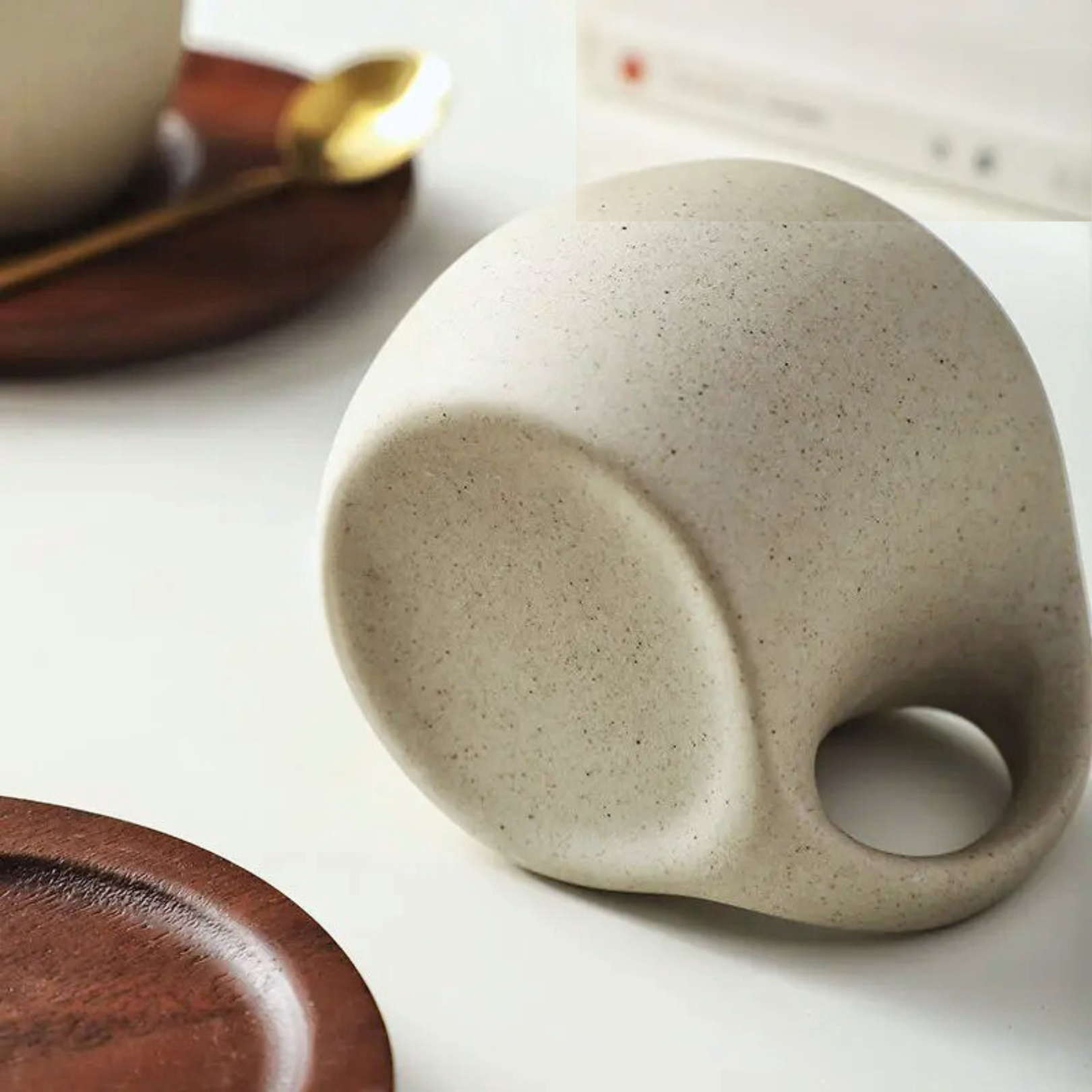 Ceramic cup resting on its side, revealing the smooth bottom finish