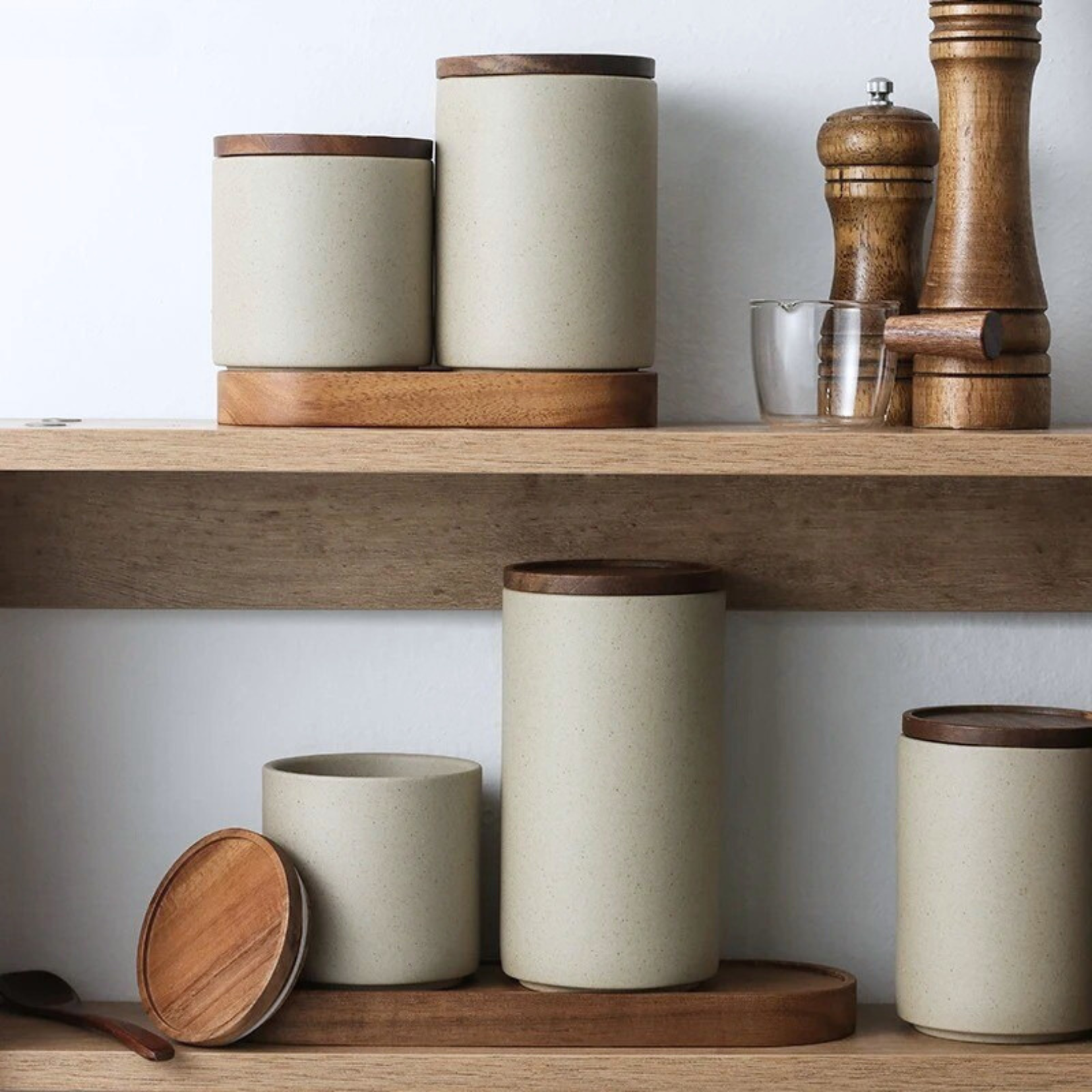  Ceramic storage jar resting on wooden holder base, placed on a pantry shelf