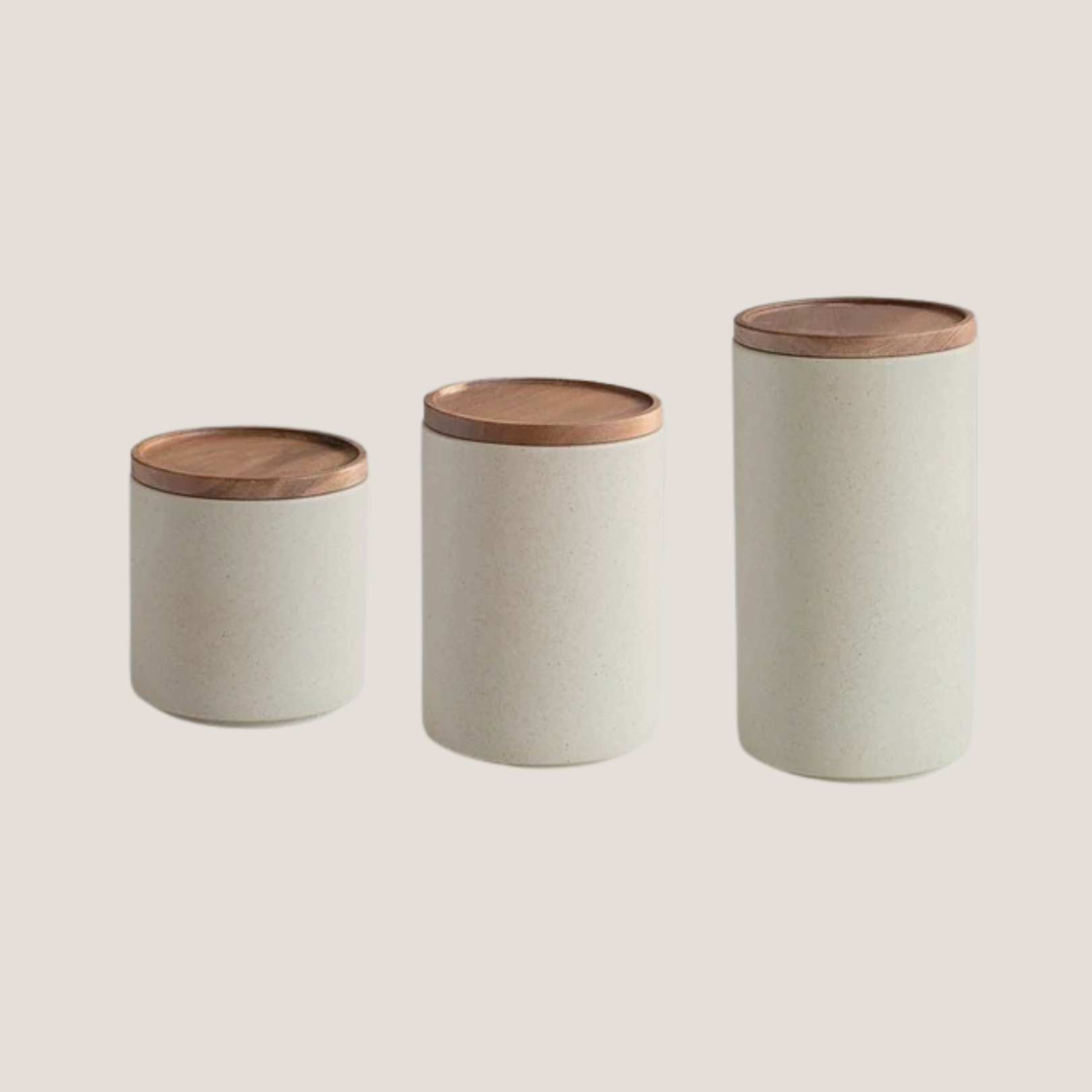 Set of three white ceramic storage jars with wooden lids displayed together