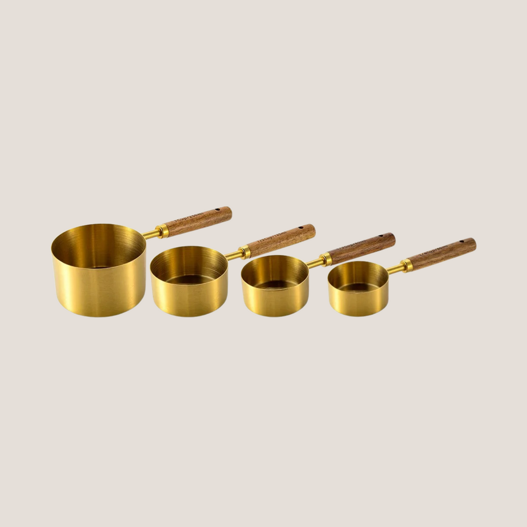 Set of gold measuring cups arranged in order from largest to smallest, neatly fanned out to show size variation