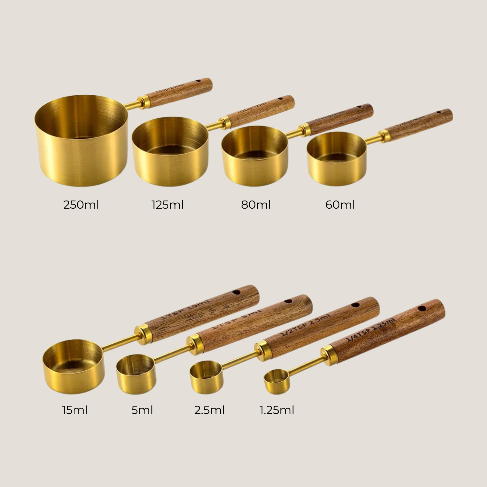 Gold measuring cups and spoons with etched volume measurements clearly visible on handles and bowls