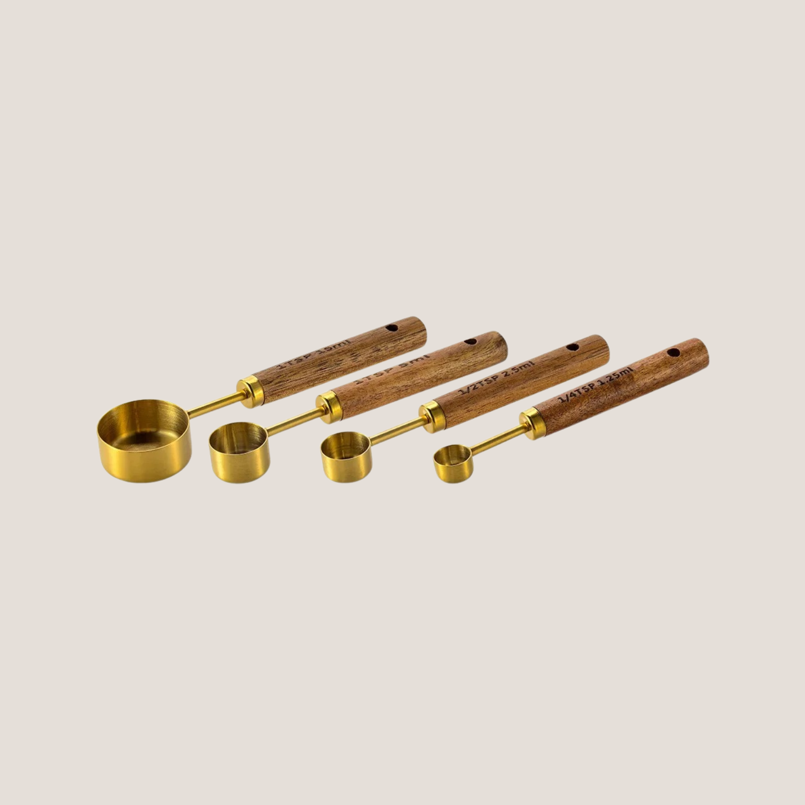 Set of gold measuring spoons arranged in order from largest to smallest, neatly fanned out to show size variation