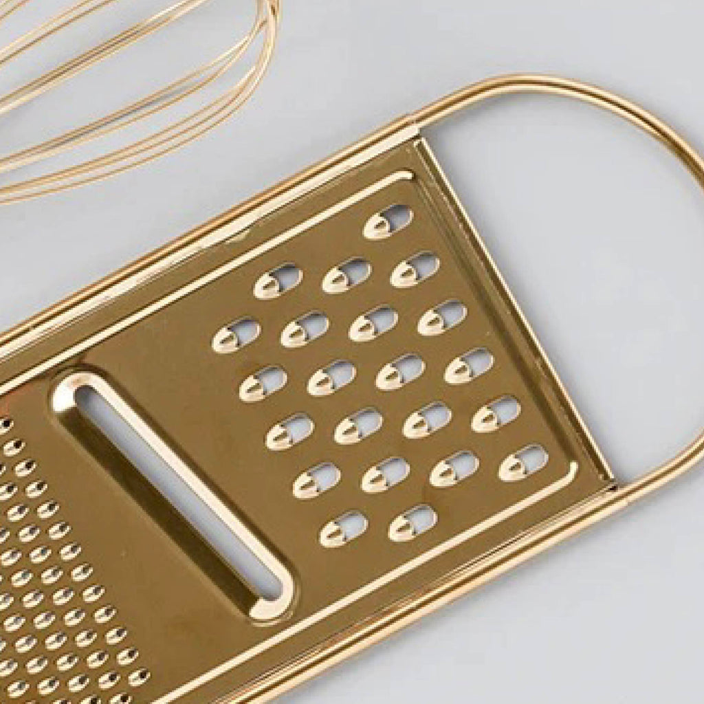 Close-up of gold grater showing sharp blades and elegant stainless handle finish