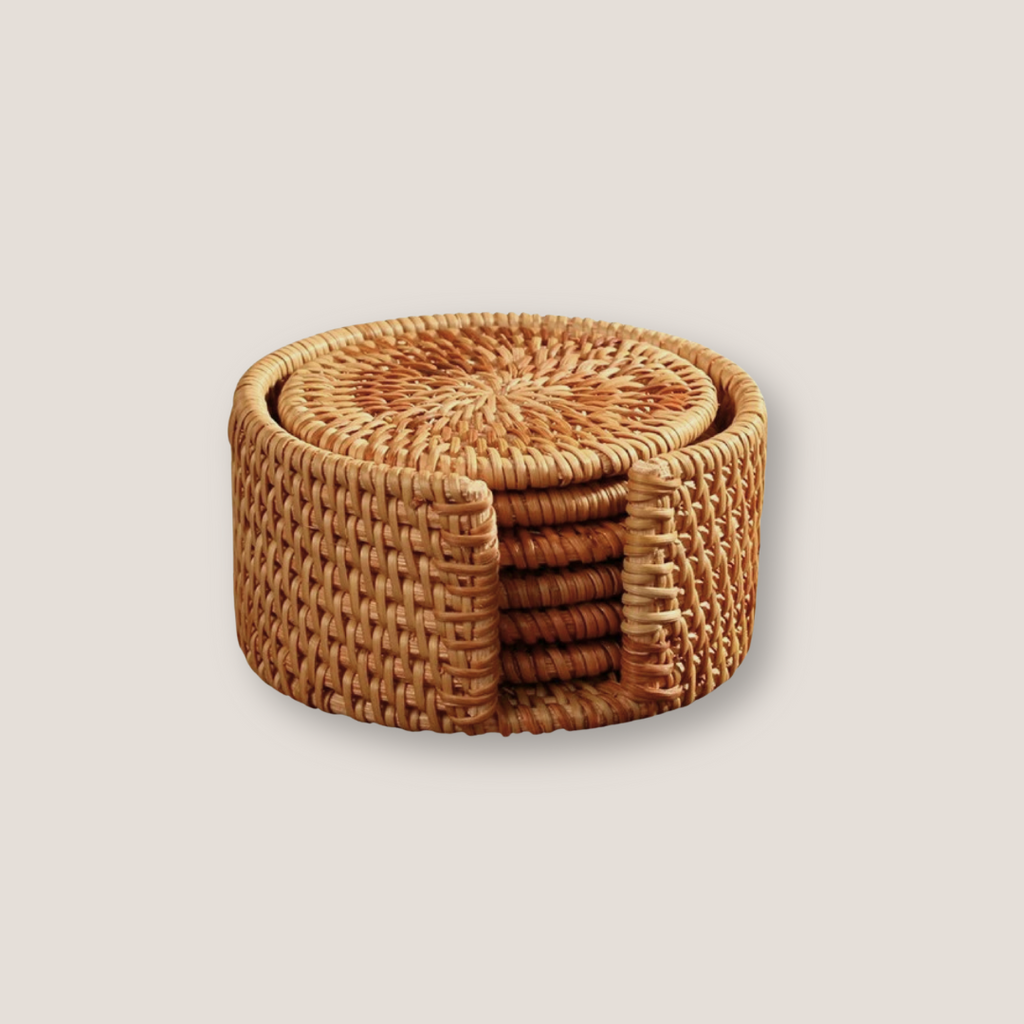 Set of round rattan placemat and coasters arranged together on a wooden table with natural texture