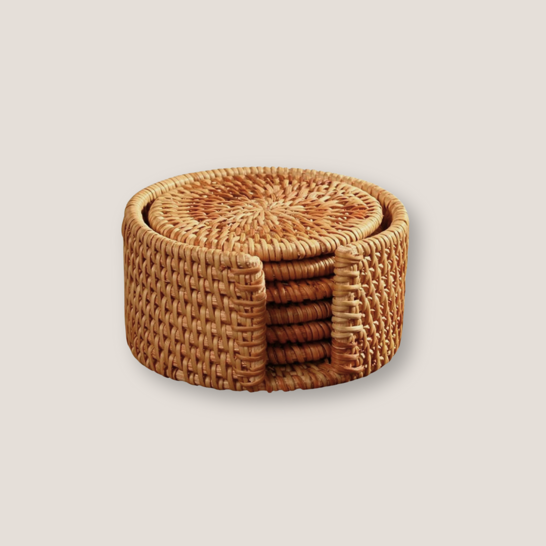 Set of round rattan placemat and coasters arranged together on a wooden table with natural texture