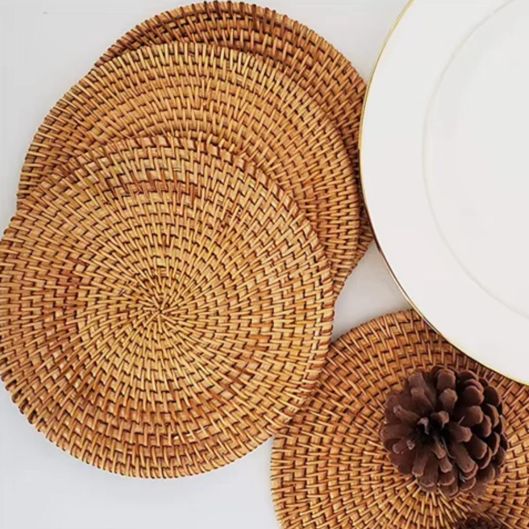 Set of rattan placemats fanned out in a semi-circle to showcase texture and craftsmanship, styled on a neutral surface