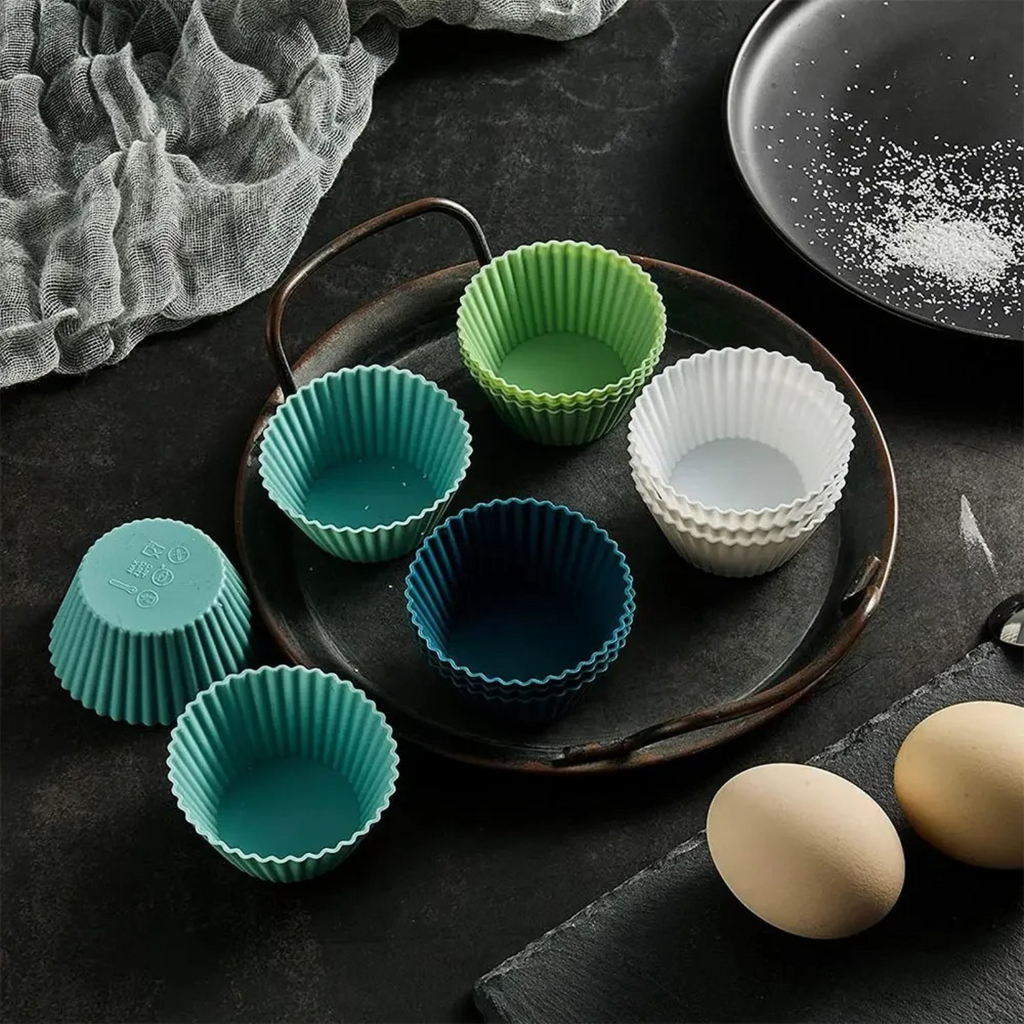 Silicone muffin cups displayed alongside baking ingredients in a stylish flat-lay kitchen setting