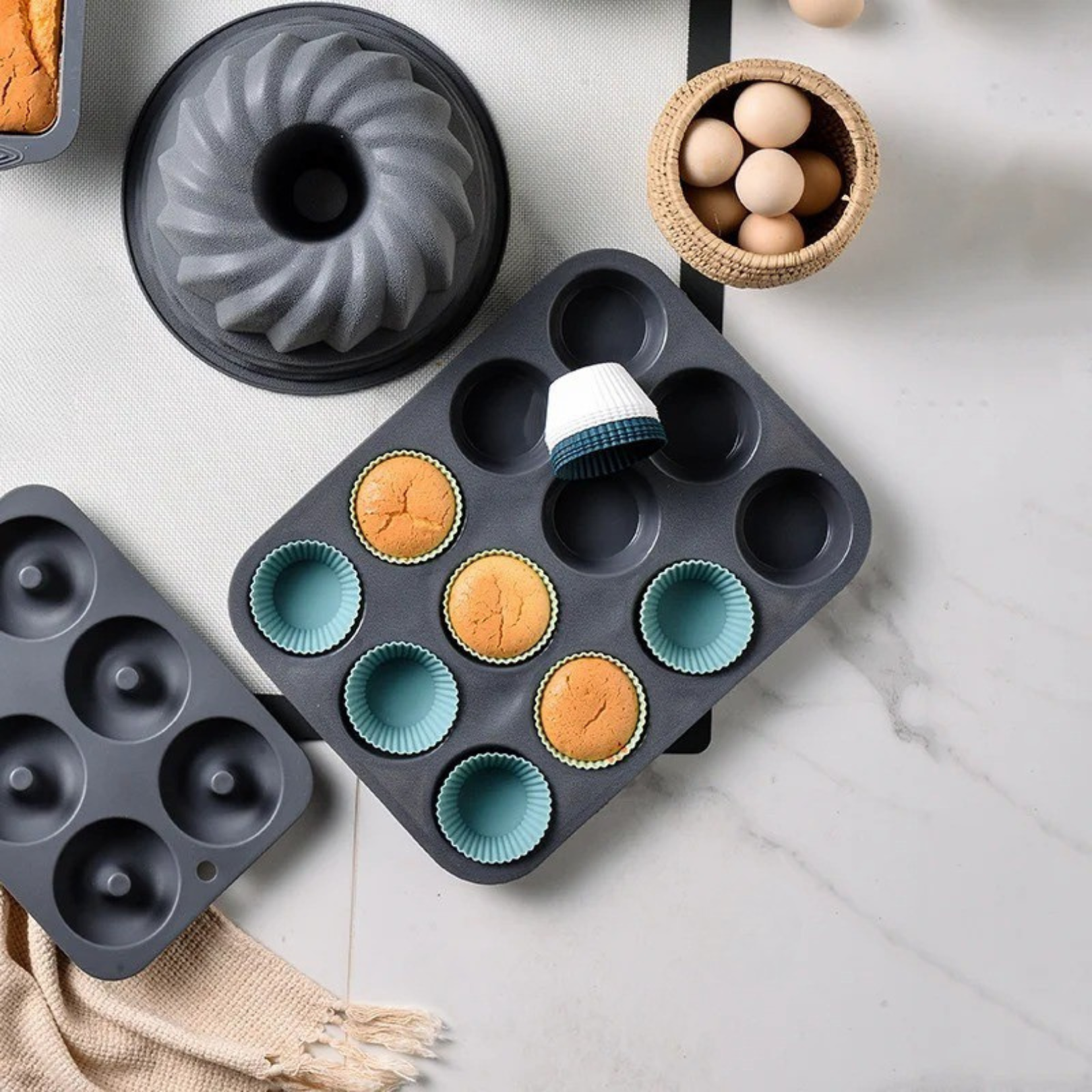 Silicone baking cups filled with muffins placed in a muffin tray on a kitchen counter