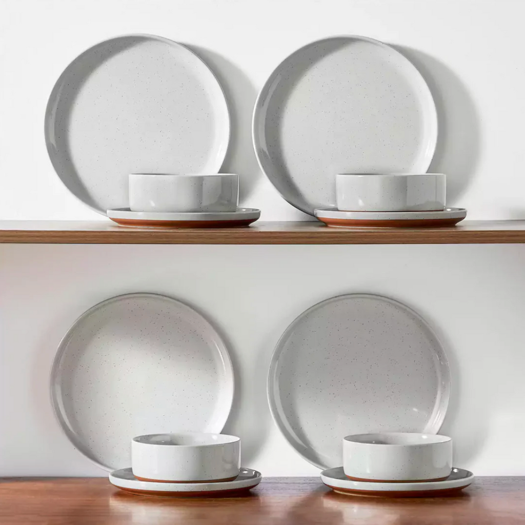 Cool gray stoneware dinnerware neatly arranged on a wooden shelf, showcasing its warm tones and rustic charm