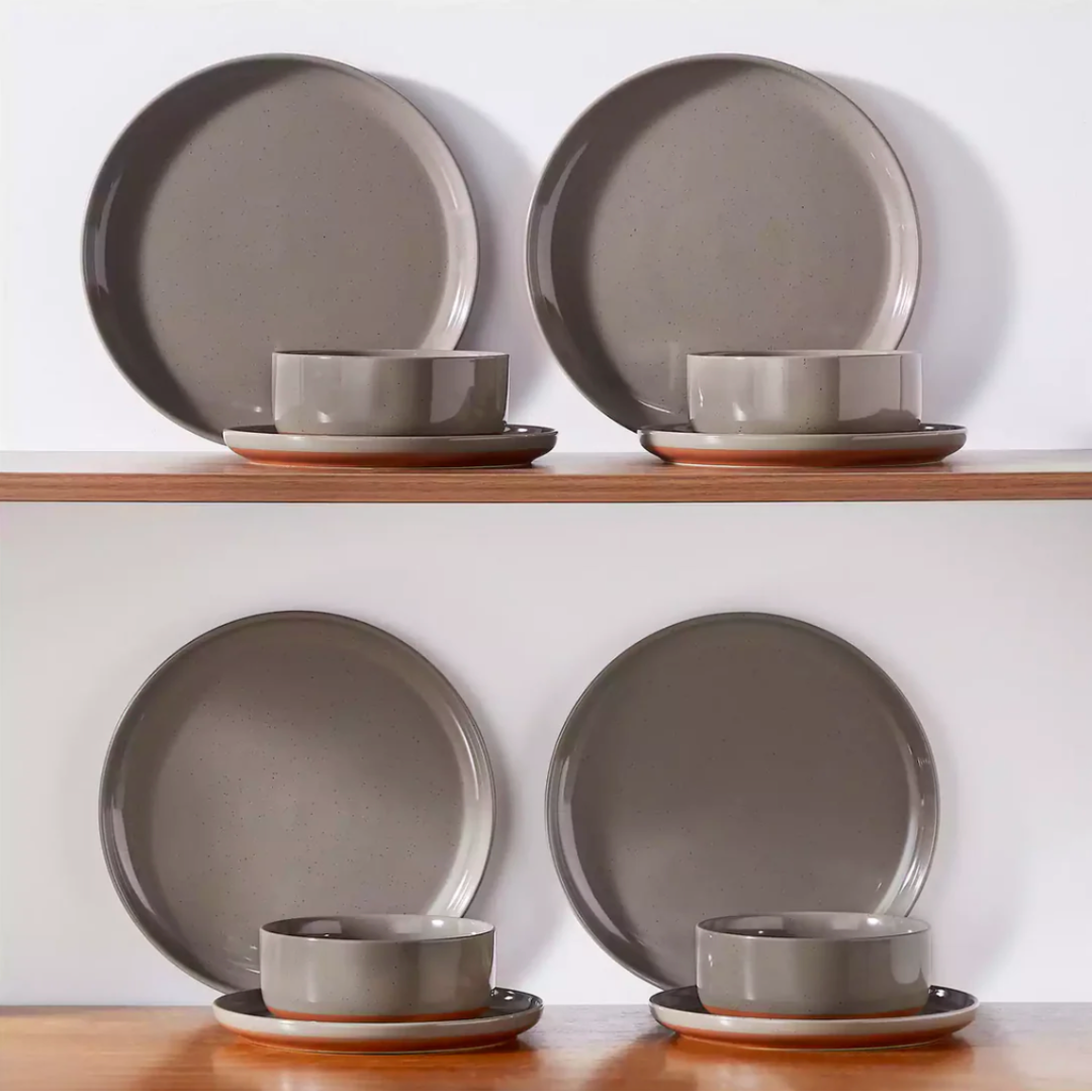 Earthy brown stoneware dinnerware neatly arranged on a wooden shelf, showcasing its warm tones and rustic charm
