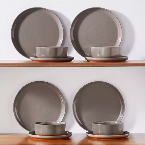 Earthy brown stoneware dinnerware neatly arranged on a wooden shelf, showcasing its warm tones and rustic charm