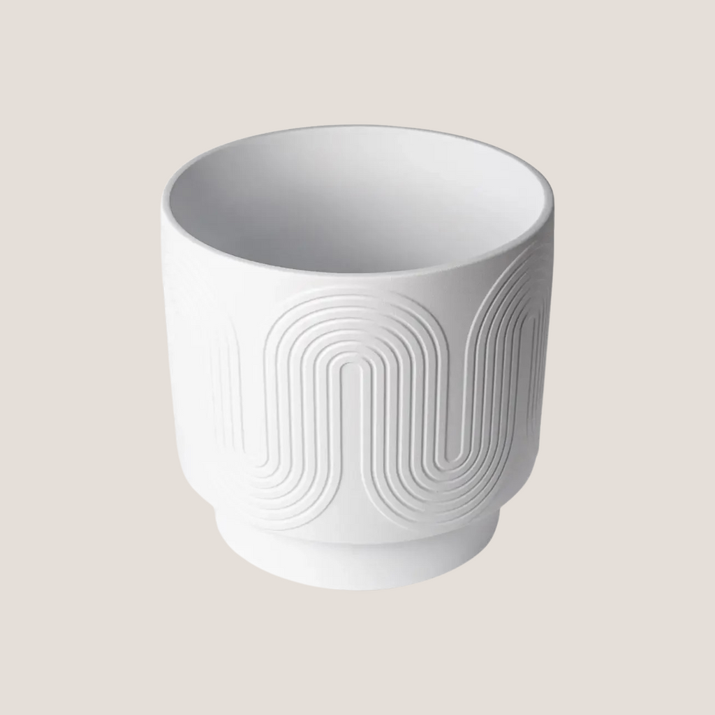 Side angle view of white ceramic planter highlighting its curved profile and embossed texture