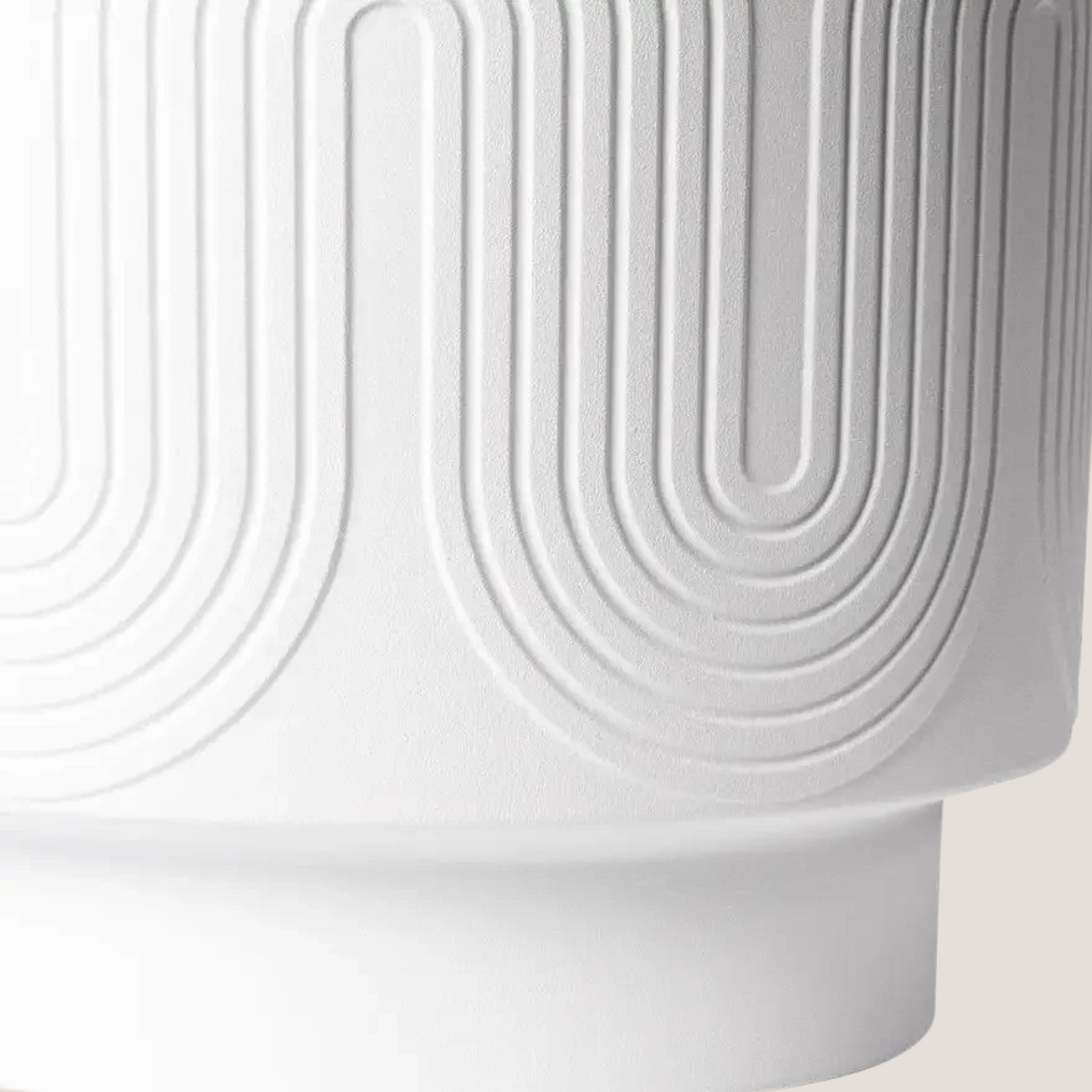 Close-up of white ceramic planter highlighting its wavy embossed texture and matte finish