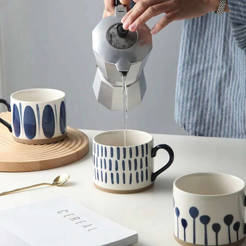Woman pouring hot coffee into a ceramic artisan mug, capturing a warm and inviting moment.