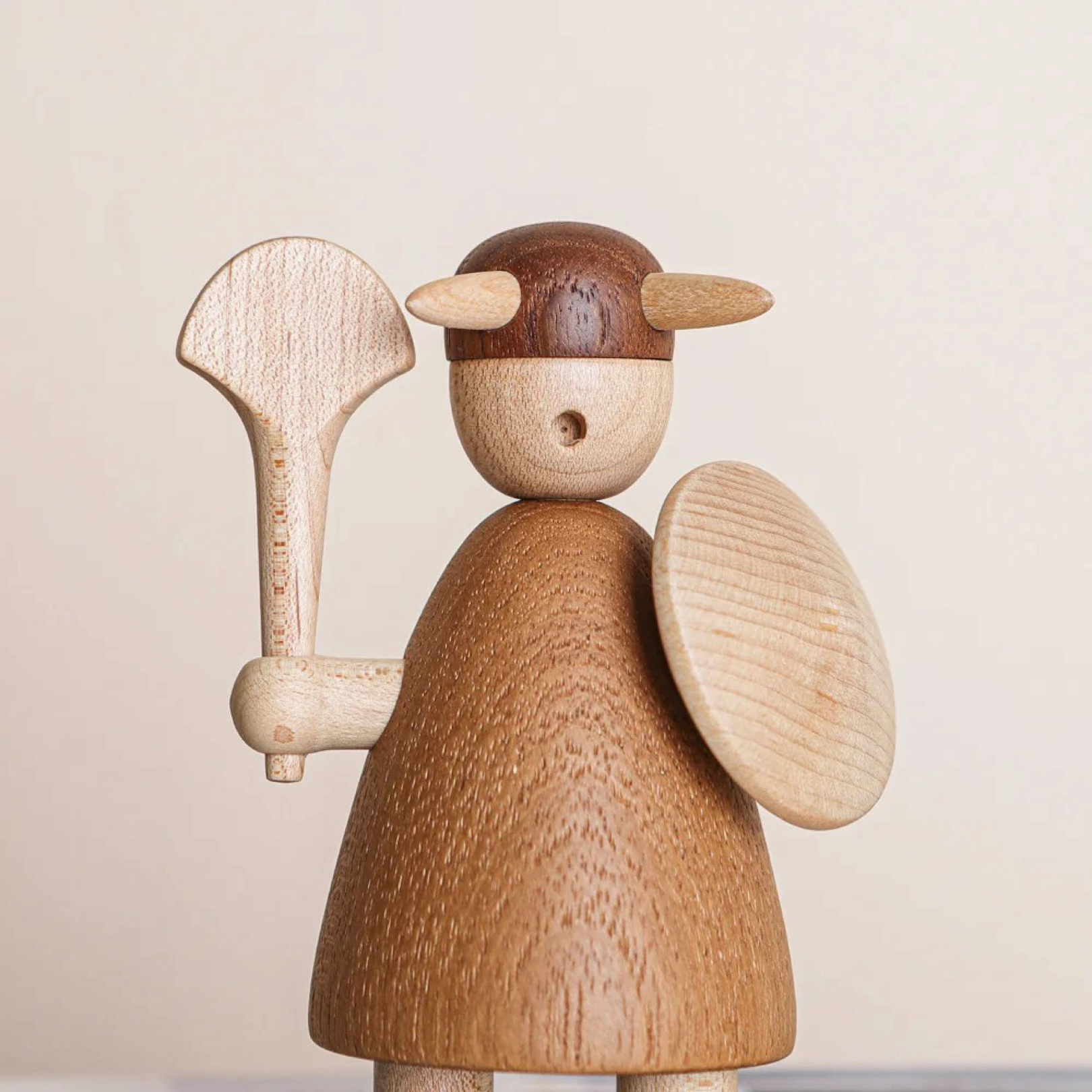 Close-up of wooden Viking figurine wearing a horned helmet