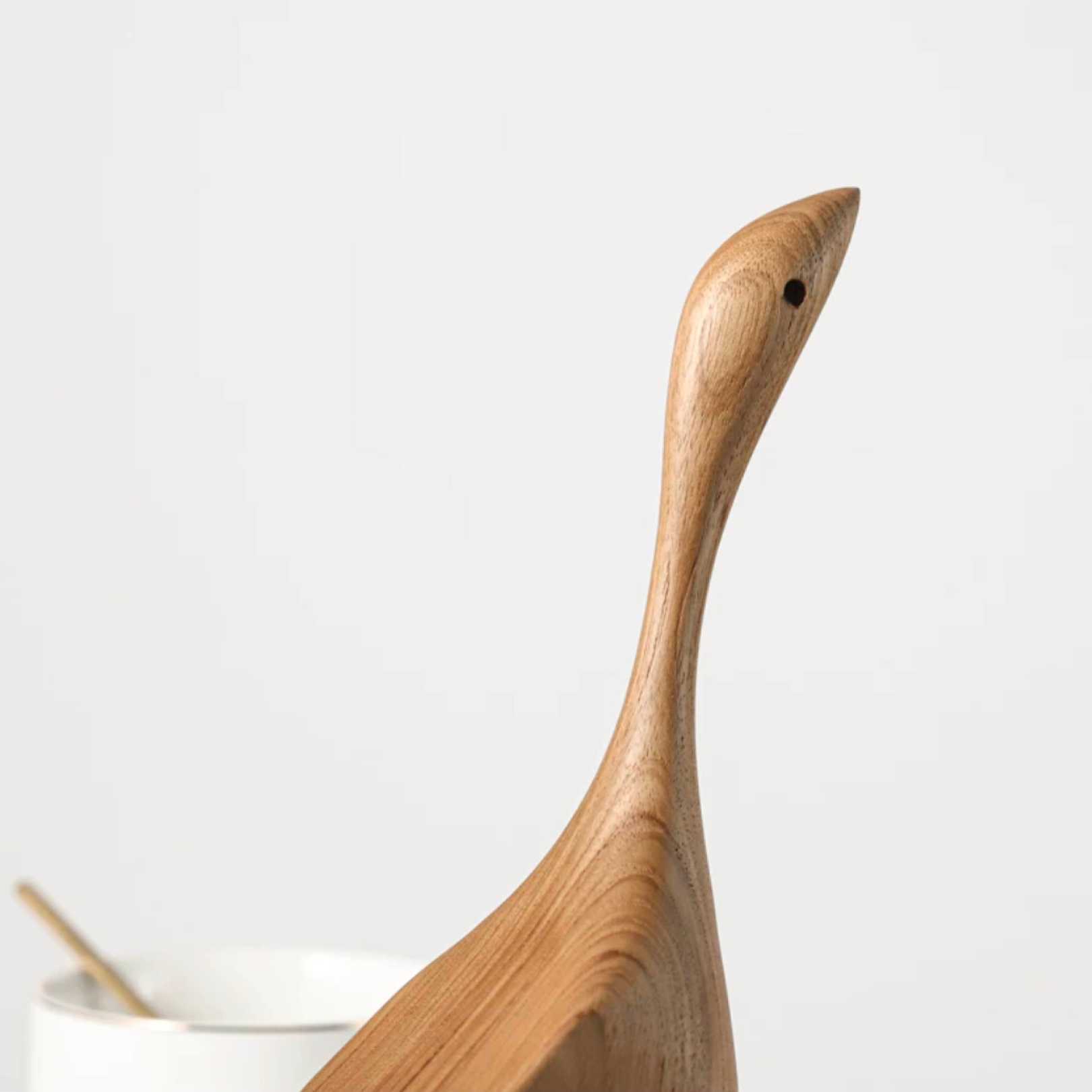 Close-up of wooden goose figurine on white background