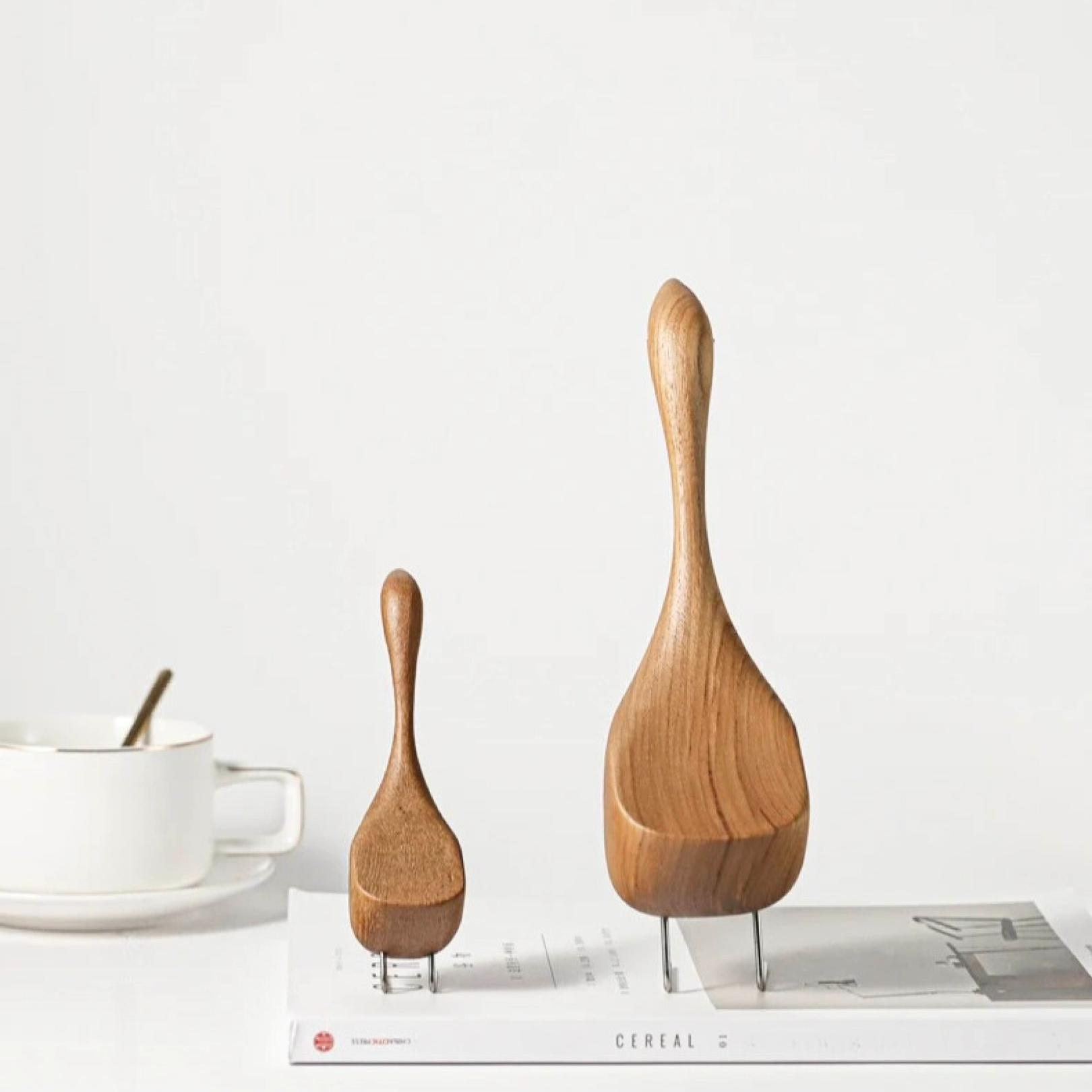 Back view of wooden goose figurines showing tail and carved wood grain