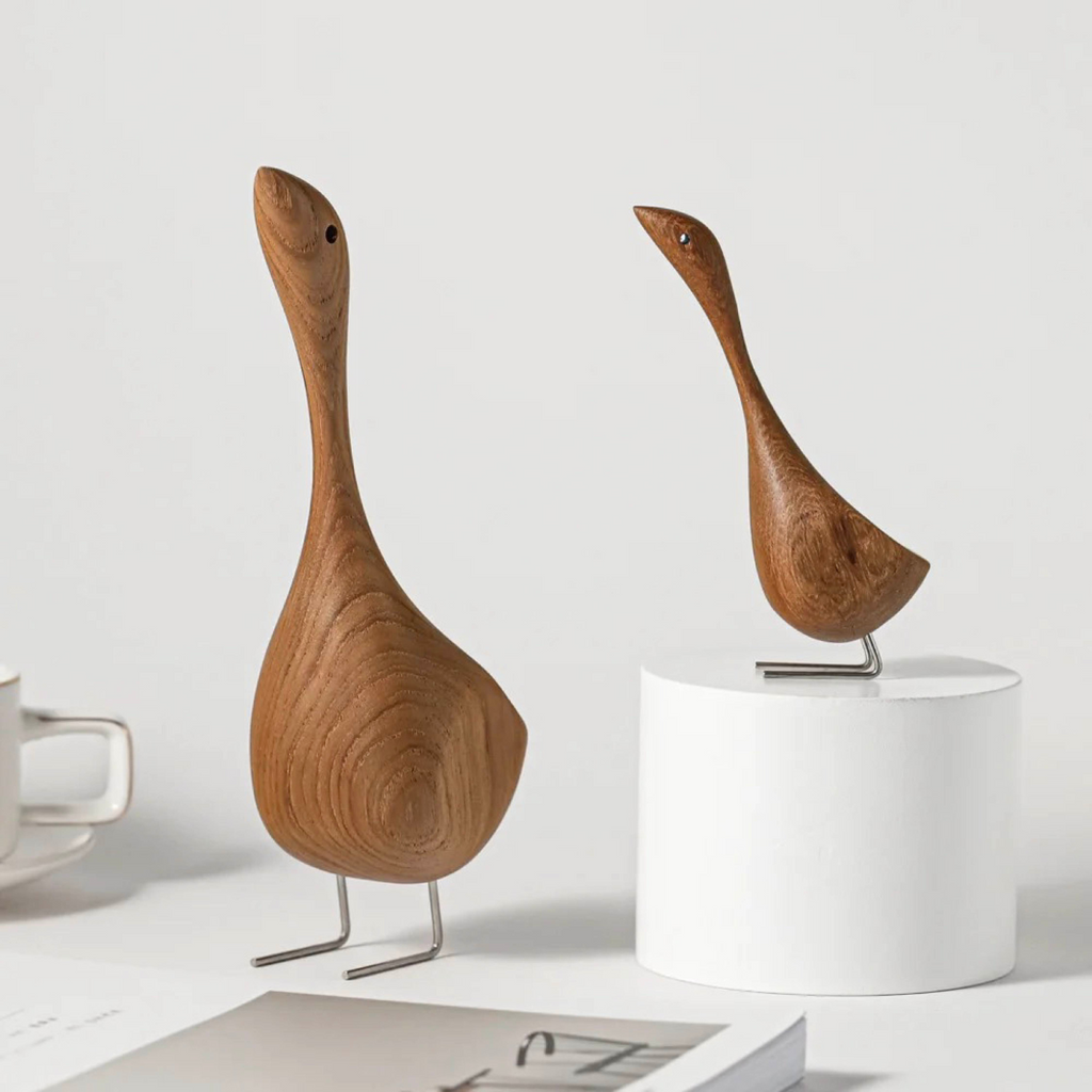 Wooden goose figurines styled as home decor on a shelf with minimal accessories