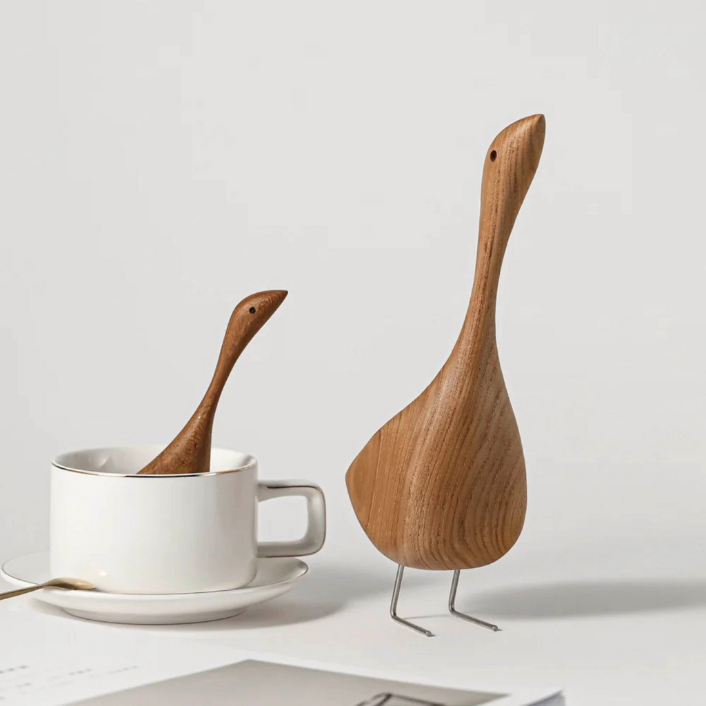 Handcrafted wooden goose figurines shown on a white background 