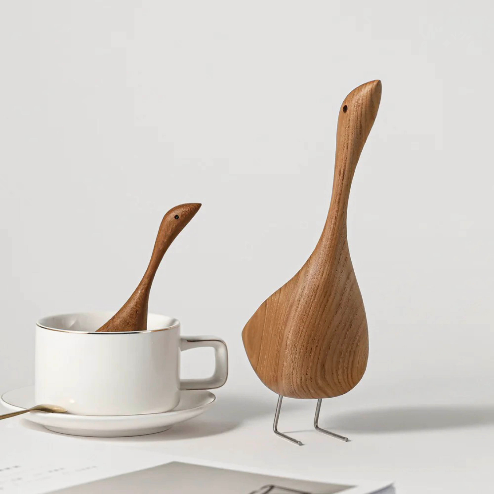 Handcrafted wooden goose figurines shown on a white background 