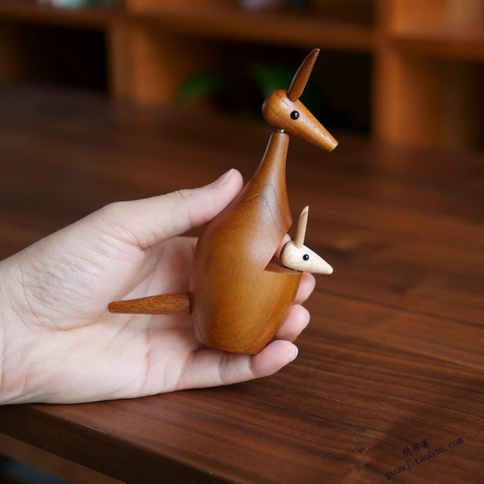 Wooden kangaroo decor with baby being held in hand to show size and scale